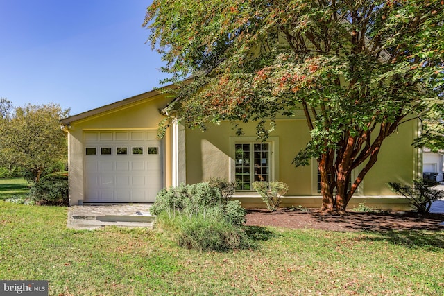 view of front of home with a front lawn and a garage