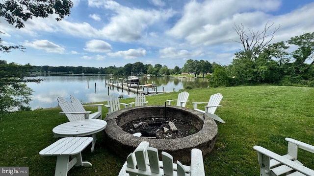 view of patio / terrace featuring an outdoor fire pit, a boat dock, and a water view