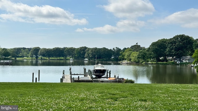 view of dock with a water view and a yard