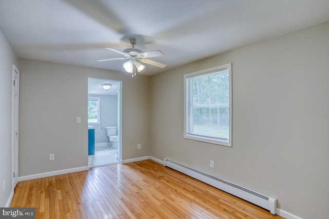 empty room with a baseboard heating unit, ceiling fan, and light hardwood / wood-style floors