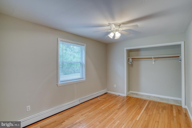 unfurnished bedroom featuring a baseboard heating unit, a closet, ceiling fan, and light wood-type flooring