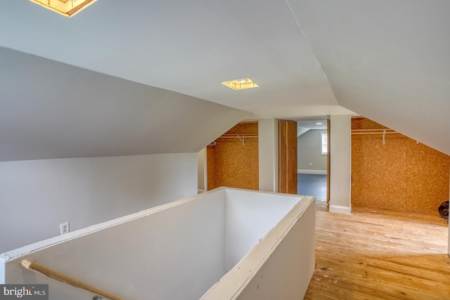 bonus room with lofted ceiling and light hardwood / wood-style floors