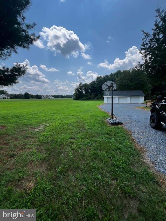 view of yard with a garage and a rural view