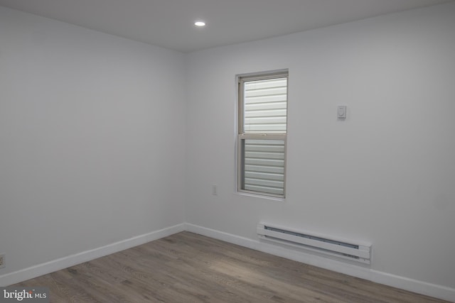 unfurnished room featuring light hardwood / wood-style flooring and baseboard heating