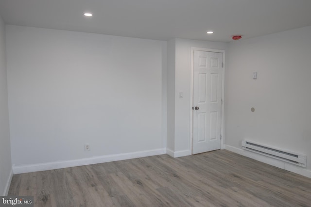 spare room featuring light hardwood / wood-style flooring and a baseboard heating unit