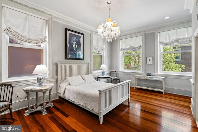 bedroom featuring dark hardwood / wood-style floors, crown molding, and an inviting chandelier