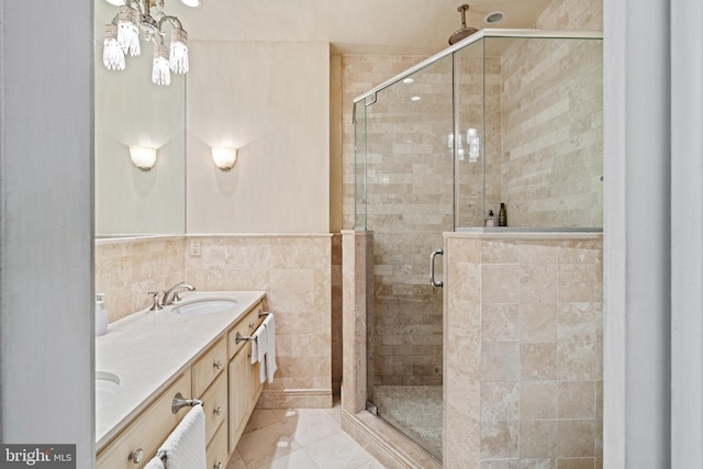 bathroom featuring tile patterned flooring, vanity, an enclosed shower, and tile walls