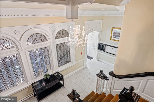 interior space featuring a notable chandelier, light tile patterned flooring, and ornamental molding