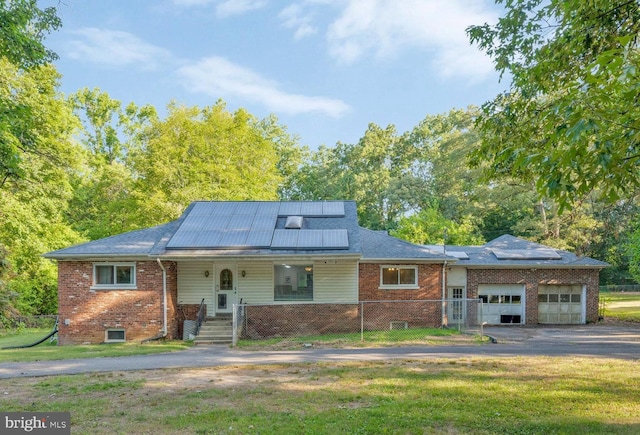 ranch-style house with covered porch, a front yard, and solar panels