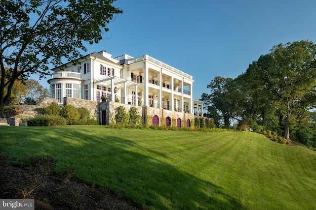 exterior space featuring a lawn and a balcony