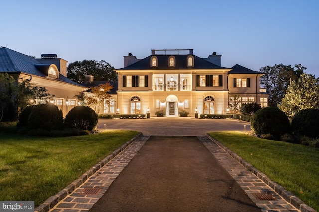 view of front of home featuring french doors and a lawn