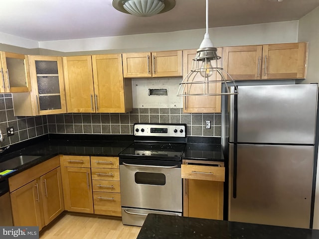 kitchen featuring backsplash, sink, stainless steel appliances, and light wood-type flooring