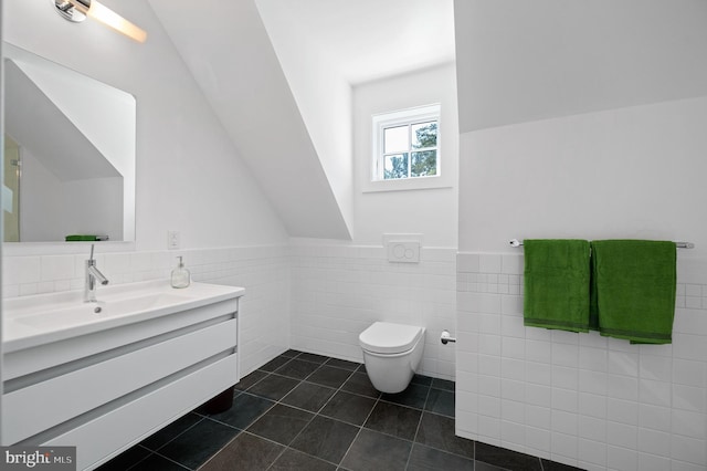 bathroom with tile patterned floors, vanity, tile walls, and toilet