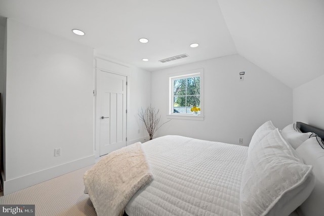 carpeted bedroom with lofted ceiling