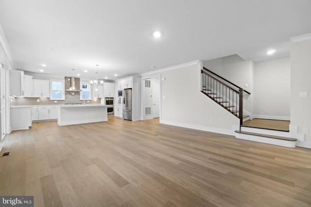 unfurnished living room featuring light hardwood / wood-style flooring and crown molding