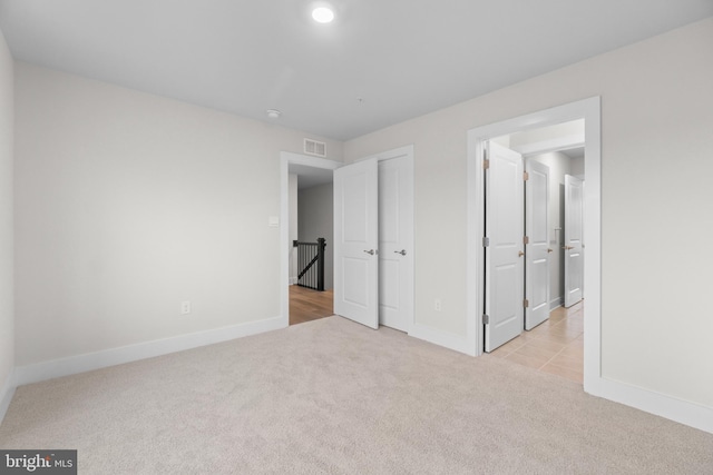 unfurnished bedroom with light colored carpet