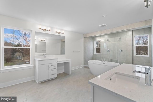 bathroom featuring tile patterned floors, vanity, and a tile shower