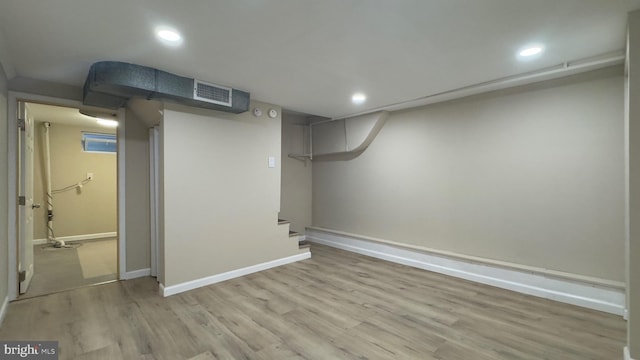 basement with light hardwood / wood-style flooring