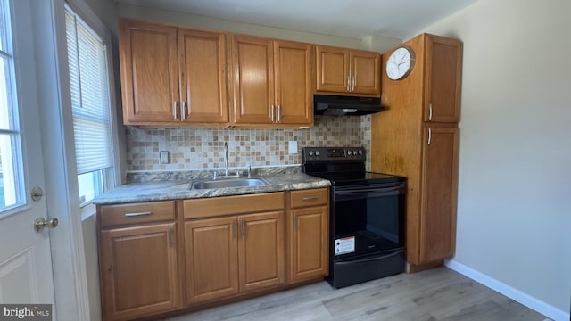 kitchen featuring sink, backsplash, black range with electric stovetop, and light hardwood / wood-style floors