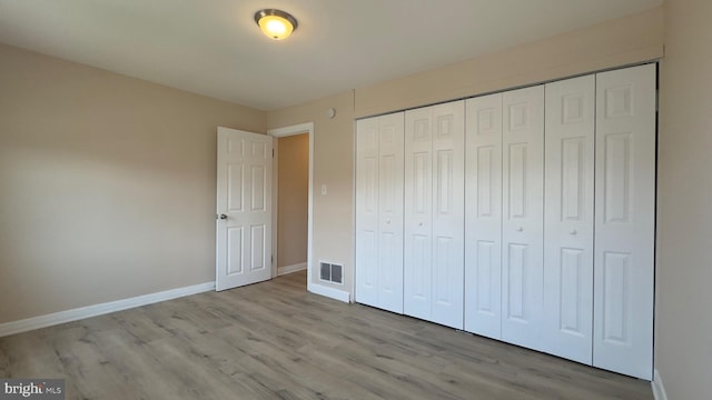 unfurnished bedroom featuring light wood-type flooring and a closet