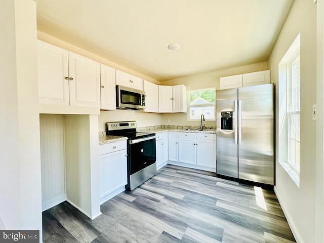 kitchen featuring white cabinets, plenty of natural light, sink, and appliances with stainless steel finishes