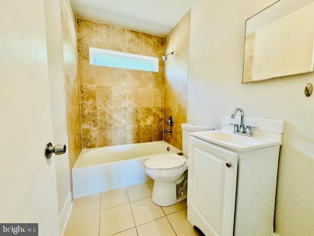 full bathroom featuring tile patterned floors, vanity, toilet, and tiled shower / bath