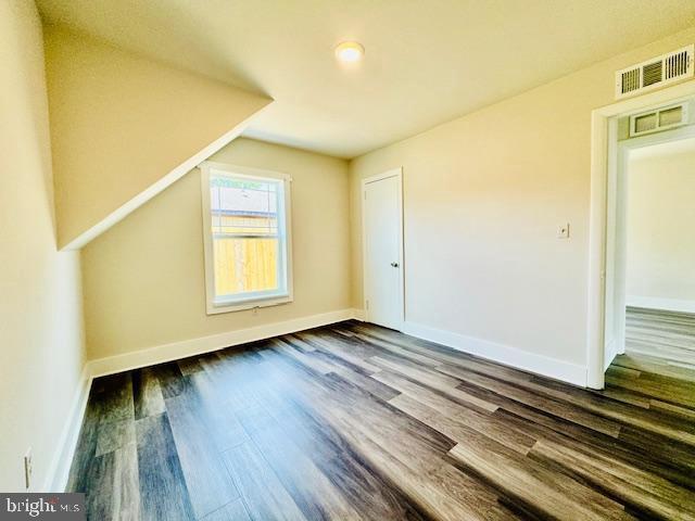 bonus room with dark hardwood / wood-style flooring