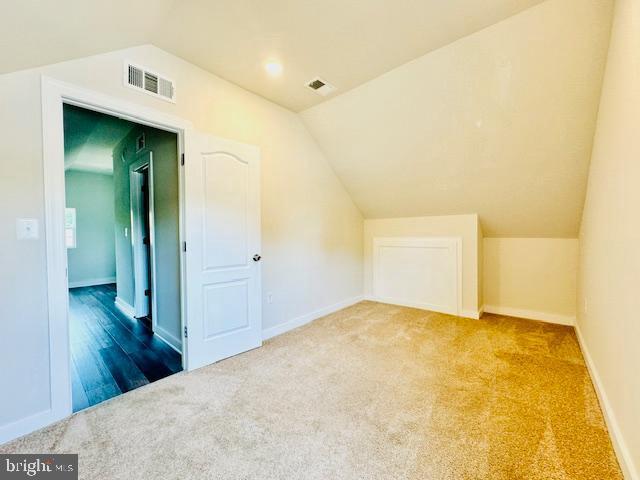 bonus room featuring carpet and vaulted ceiling