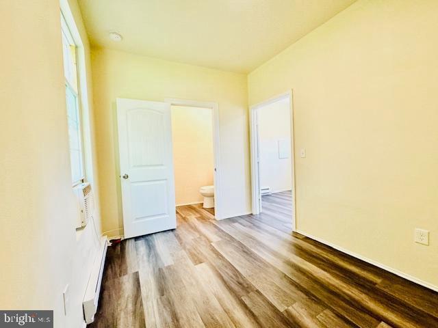 spare room with a baseboard radiator and hardwood / wood-style flooring