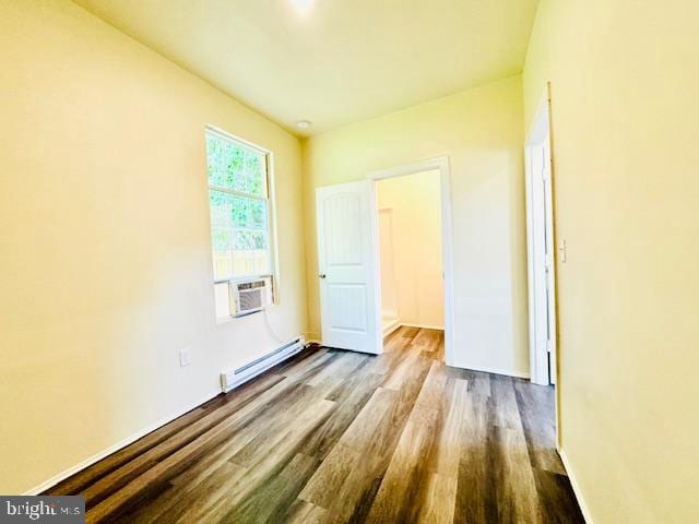 unfurnished room featuring cooling unit, wood-type flooring, and baseboard heating