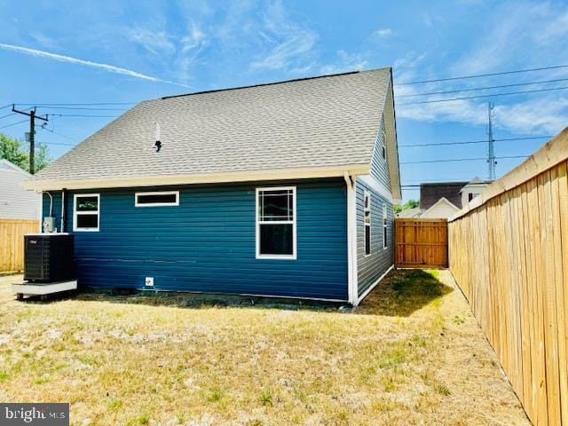 back of property featuring a lawn and central AC unit