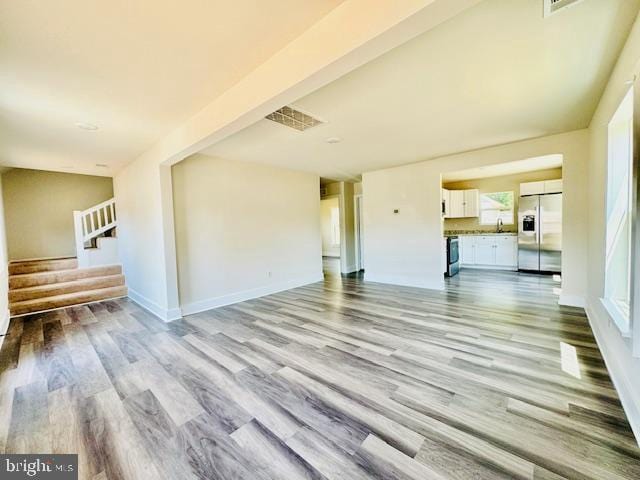 unfurnished living room featuring light wood-type flooring and sink