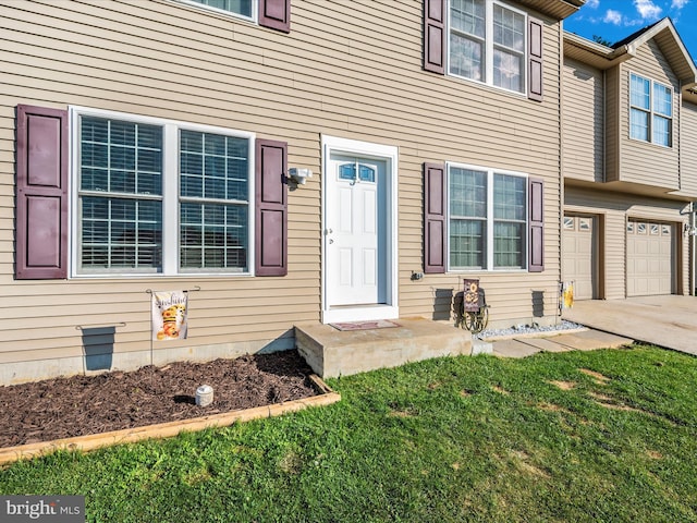 doorway to property featuring a garage and a yard