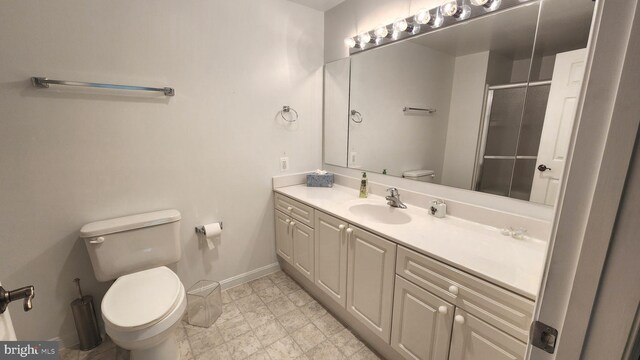 bathroom featuring vanity, a shower with shower door, and toilet