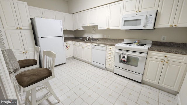 kitchen with white cabinets, white appliances, and sink