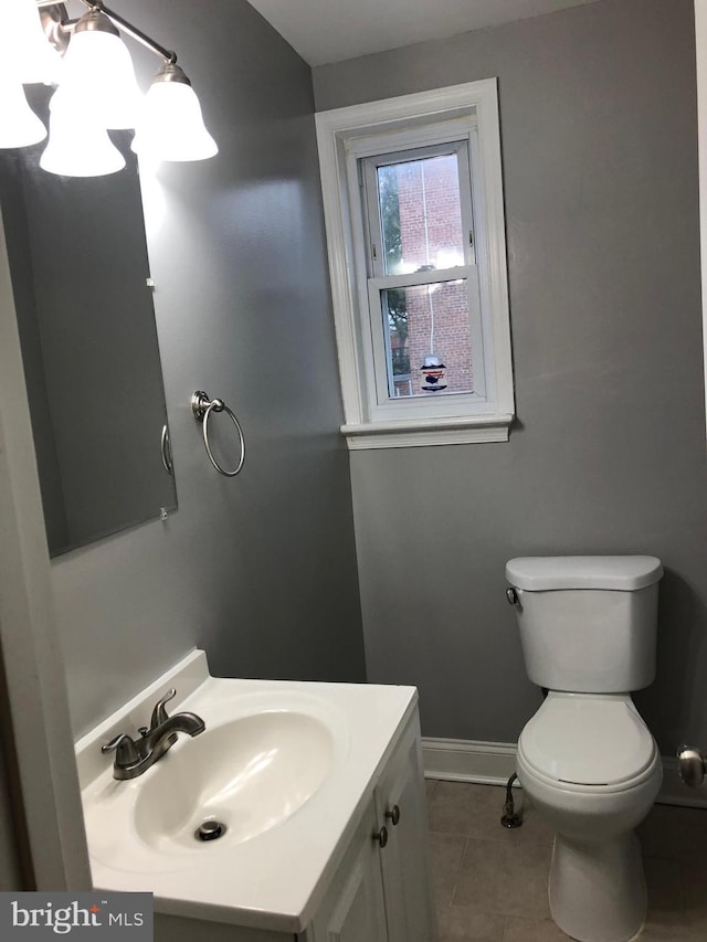 bathroom with toilet, vanity, and tile patterned floors