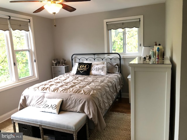 bedroom with multiple windows, ceiling fan, and hardwood / wood-style flooring