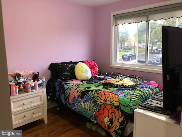 bedroom with dark hardwood / wood-style floors