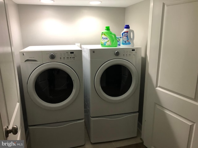 laundry area with washing machine and clothes dryer and tile patterned floors