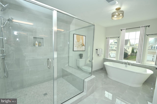 bathroom featuring tile patterned flooring, toilet, and independent shower and bath