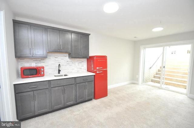 kitchen with backsplash, light carpet, and sink