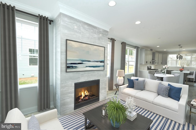 living room featuring crown molding and a tiled fireplace