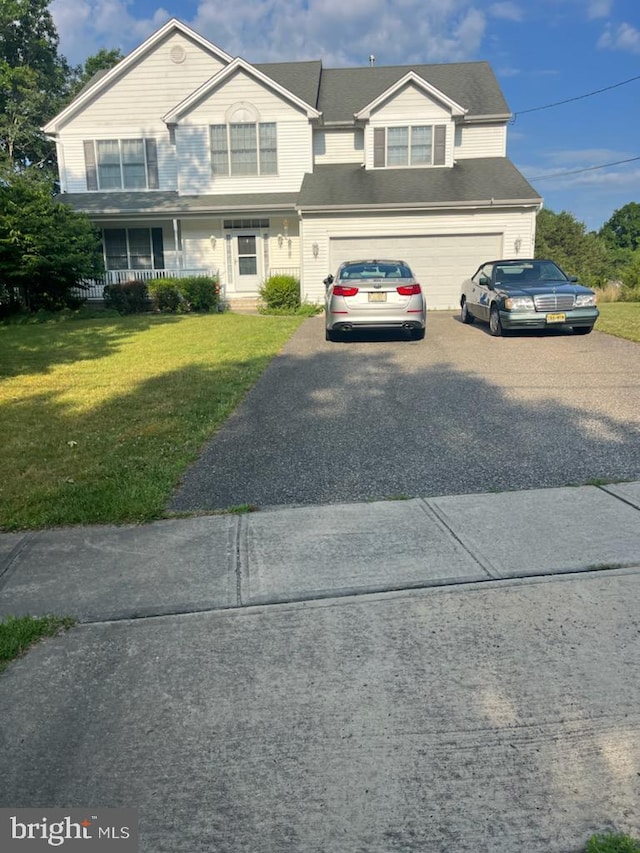 view of front facade featuring a front yard, a porch, and a garage