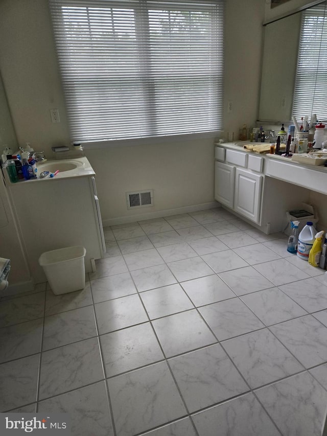 bathroom featuring visible vents, vanity, and baseboards