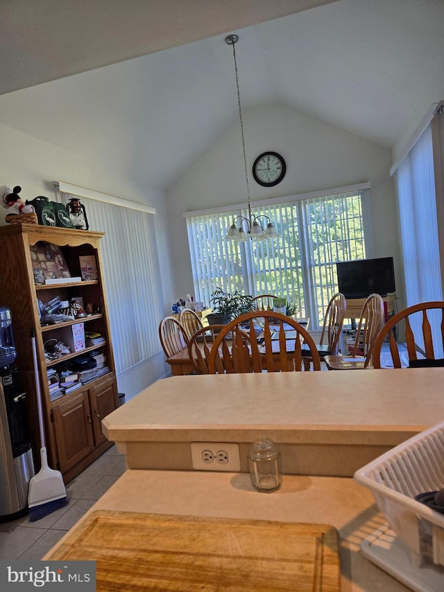 dining room with lofted ceiling, light tile patterned floors, and a chandelier