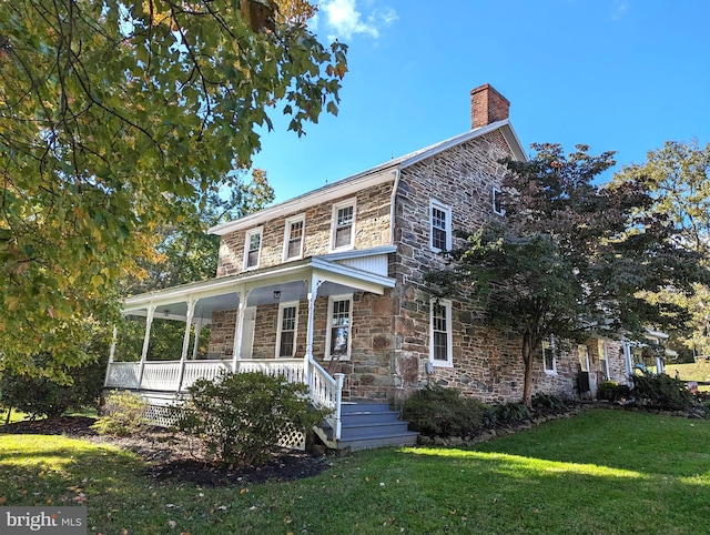 view of front of property with a front yard and covered porch