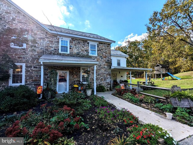 view of front of house with a playground and a porch