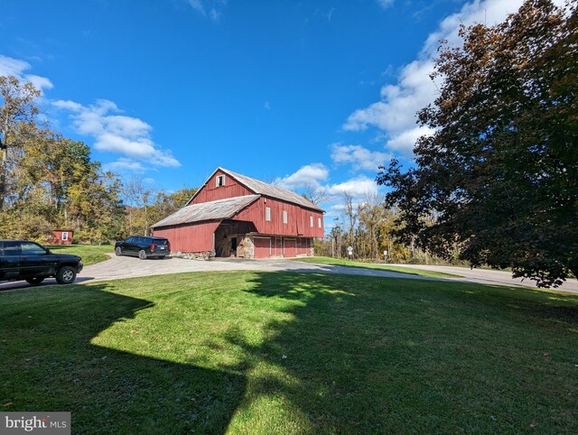 view of side of property with an outbuilding and a yard