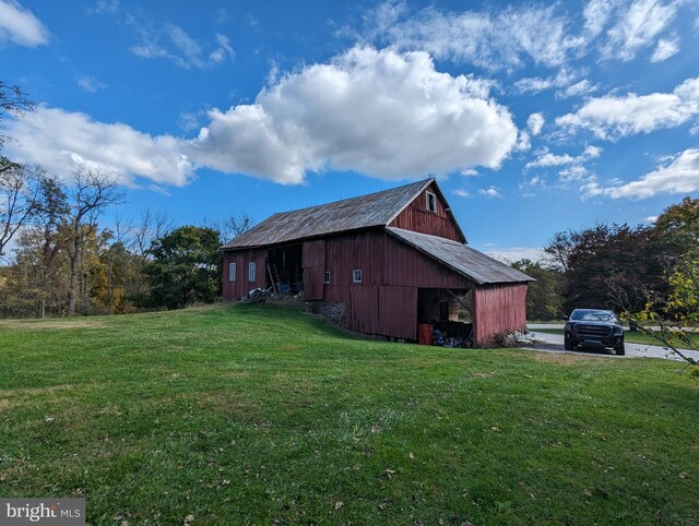 view of side of home with an outdoor structure and a lawn