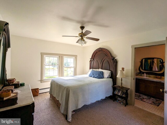 carpeted bedroom with ceiling fan, baseboard heating, and ensuite bath